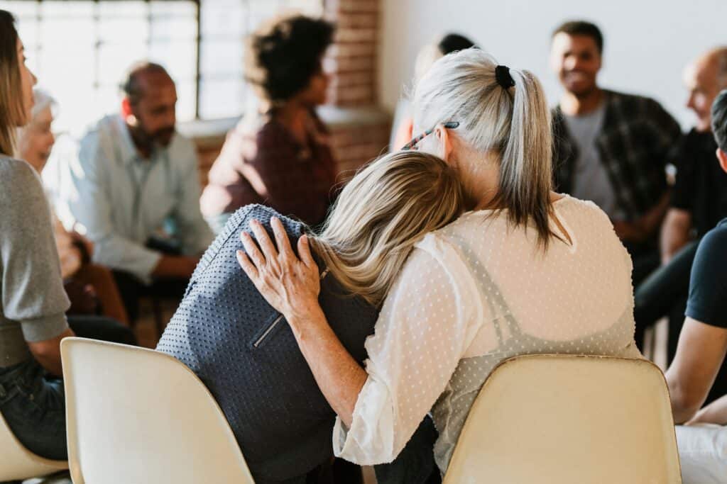 two Women comfort one another during group therapy in California 